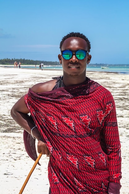 Afrykański mężczyzna w tradycyjnych strojach na plaży na wyspie Zanzibar. Tanzania