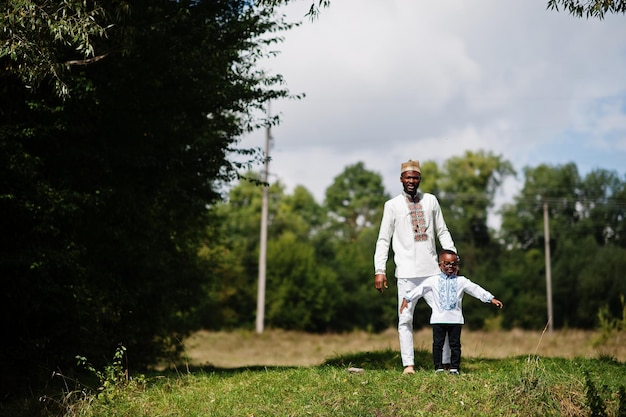 Afrykański ojciec z synem w tradycyjnych strojach w parku