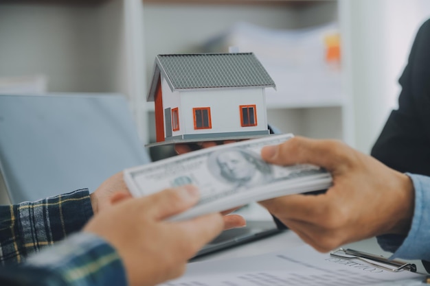 Agent nieruchomości i klient podpisują umowę na zakup ubezpieczenia nieruchomości lub pożyczki nieruchomości.