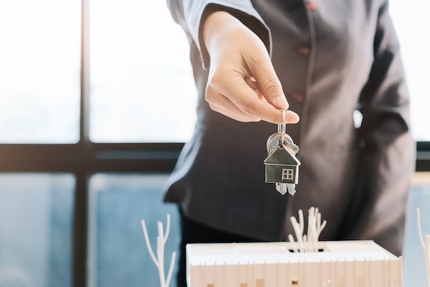 Agent nieruchomości przekazujący klucz do domu klientowi