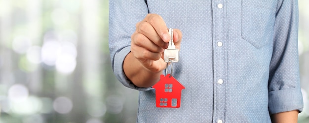 Agent nieruchomości w ręku przekazuje klucze do domu