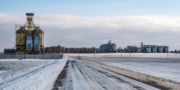 Agro silosy elewator spichlerza w zimowy dzień na zaśnieżonym polu