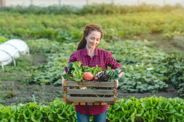 Agronom kobieta rolnik trzyma pudełko świeżych warzyw