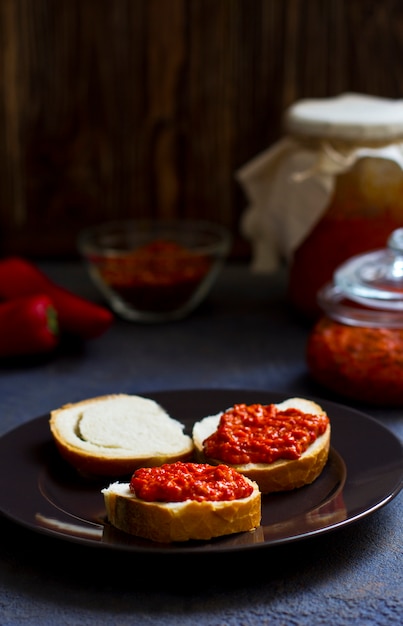 Ajvar, przystawka z pieczonej papryki na stole, chleb z ajvar, tost z ajvar, bałkańska przystawka z pieczonej papryki, pionowa, miejsce na tekst