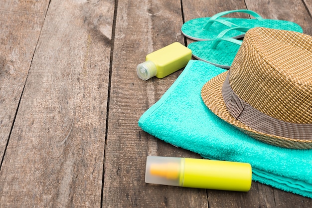 Akcesoria na wakacje na plaży, takie jak słomkowy kapelusz, klapki i ręcznik