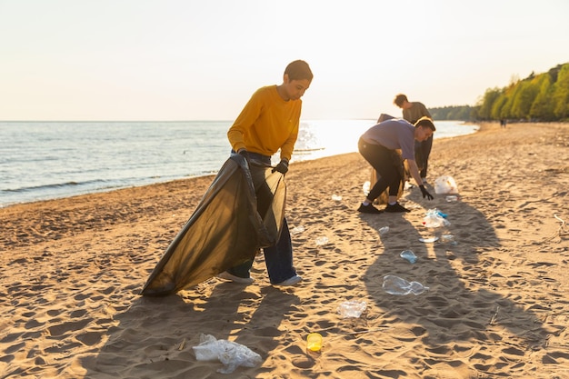 Aktywiści z okazji Dnia Ziemi zbierają śmieci na plażach w strefie przybrzeżnej dla kobiet i mężczyzn