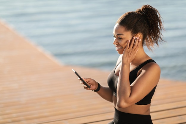 Aktywna afroamerykanka odpowiadająca na telefon podczas joggingu na świeżym powietrzu