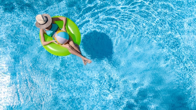 Aktywna młoda dziewczyna w basenie z lotu ptaka dronem z góry nastolatka relaksuje się i pływa na ringu