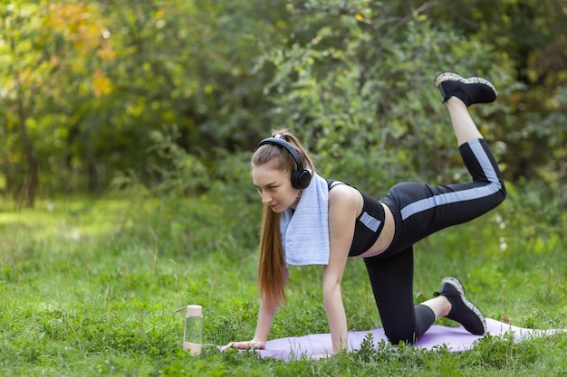 Aktywna sprawna kobieta w sportowej ćwiczeniu w parku w jasny słoneczny dzień Koncepcja fitnessu zdrowego stylu życia