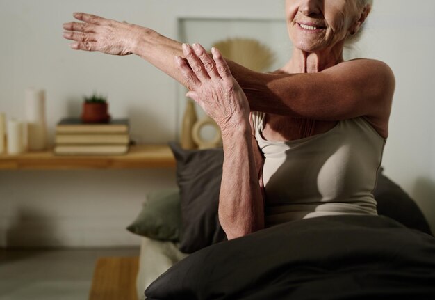Zdjęcie aktywna starsza kobieta ćwicząca w łóżku