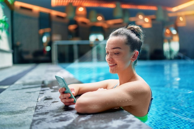 Aktywna Wysportowana Kobieta Skanuje Twarz Za Pomocą Systemu Rozpoznawania Twarzy Do Odblokowywania Telefonu Podczas Treningu Na Basenie W Centrum Fitness Spa