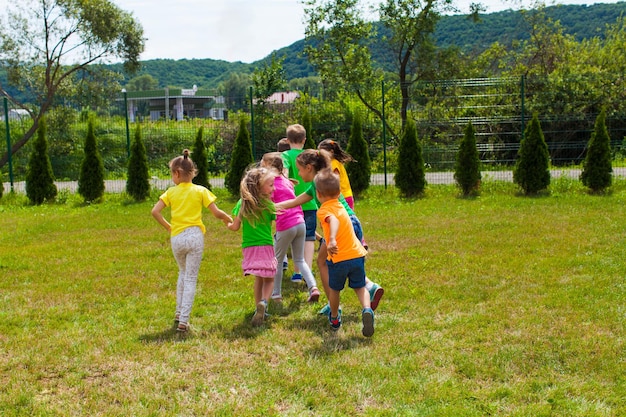 Aktywne dzieci bawią się na świeżym powietrzu na trawniku. Przyjaciele razem