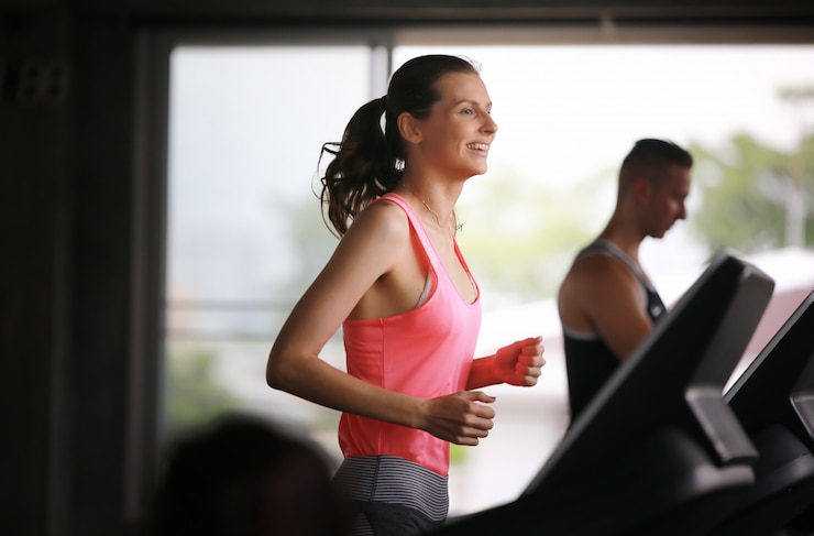 Zdjęcie aktywne kobiety biega na karuzeli przy gym