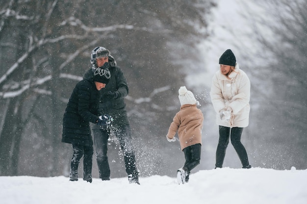 Aktywni ludzie Szczęśliwa rodzina na świeżym powietrzu cieszy się razem zimą w śniegu