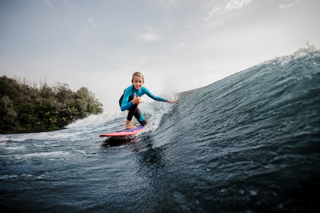 Aktywny Nastolatek Chłopak Stojący Na Jednym Kolanie Na Pomarańczowym Wakeboard