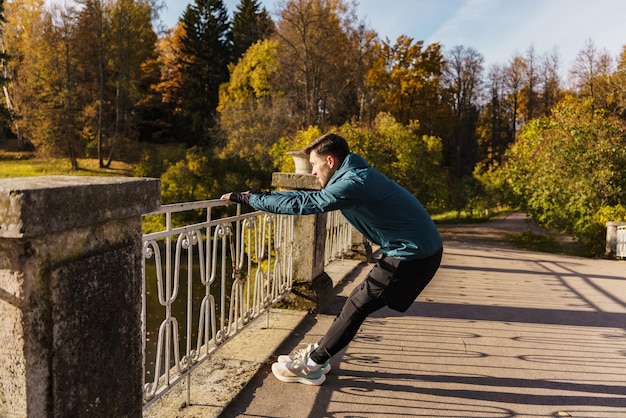 Aktywny trening zimą w parku Sportowiec codziennie ćwiczy nogi zimą Rozgrzewka