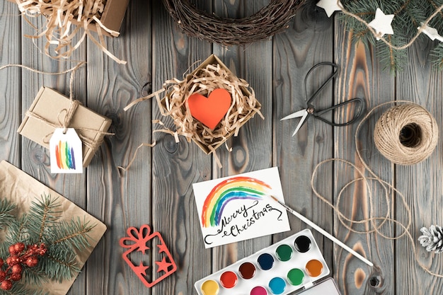 Akwarela tęczowa pocztówka i ręcznie robione pudełko w świątecznym opakowaniu widok z góry Świerkowe gałęzie i narzędzia Prezent rzemieślniczy Boże Narodzenie wakacje koncepcja Symbol LGBT orientacja homoseksualna