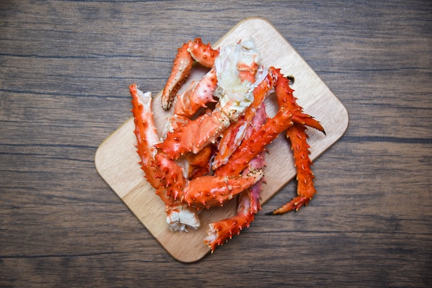 Alaskan King Crab Legs gotowane owoce morza na tle drewnianej deski do krojenia - hokkaido czerwonego kraba