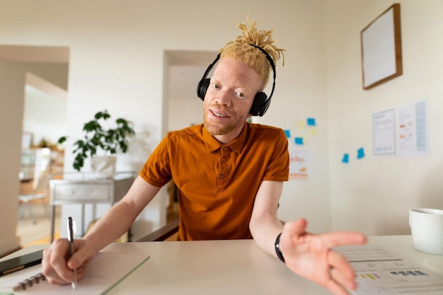 Zdjęcie albinos, afroamerykanin pracujący w domu, wykonujący rozmowy wideo