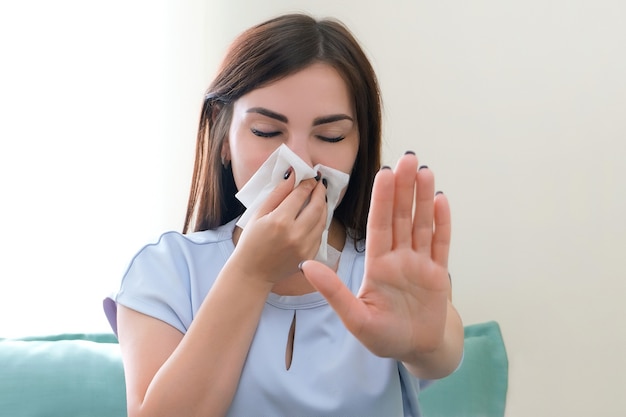 Alergia u młodej kobiety. Młoda kobieta z szalikiem na nosie. zatrzymać alergię