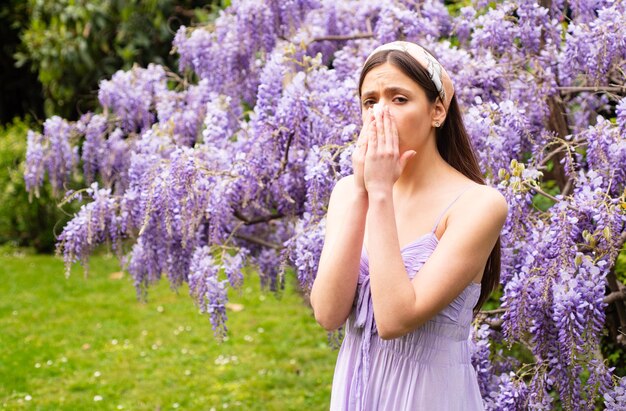 Alergia Wiosenna. Dziewczyna Z Kichaniem Nosa. Koncepcja Objawu Alergii. Kobieta Uczulona Na Kwiaty Na Zewnątrz.