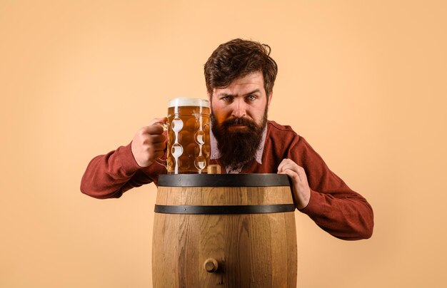Alkohol drewniana beczka szklanka piwa celebracja oktoberfest poważny brodaty mężczyzna ze szklanym piwem my