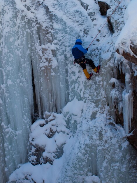 Zdjęcie alpinista wspina się po zamarzniętym wodospadzie w ice park, ouray.