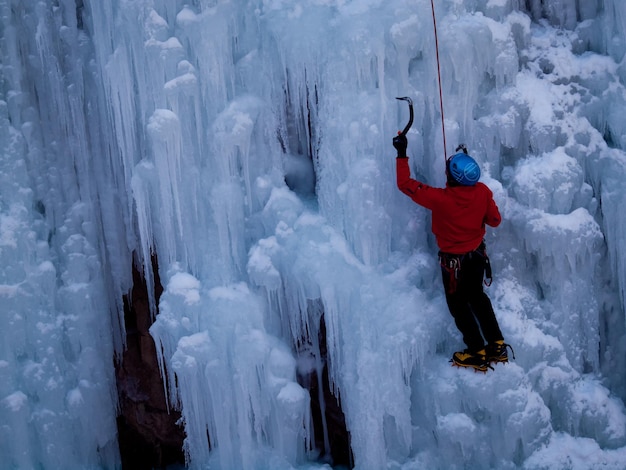 Alpinista wspina się po zamarzniętym wodospadzie w Ice Park, Ouray.