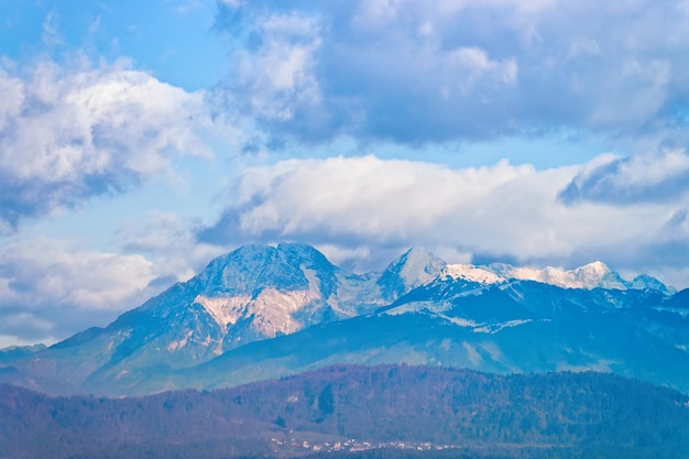 Alpy Julijskie śnieg góry krajobraz z tłem przyrody w Lublanie w Słowenii. Szczyt wzgórz z widokiem na chmury i niebo. Skalista panorama z niebieskim szlakiem alpejskim. Przygoda i podróże.