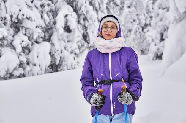 Amatorska narciarka spaceruje w zimowym, zaśnieżonym lesie