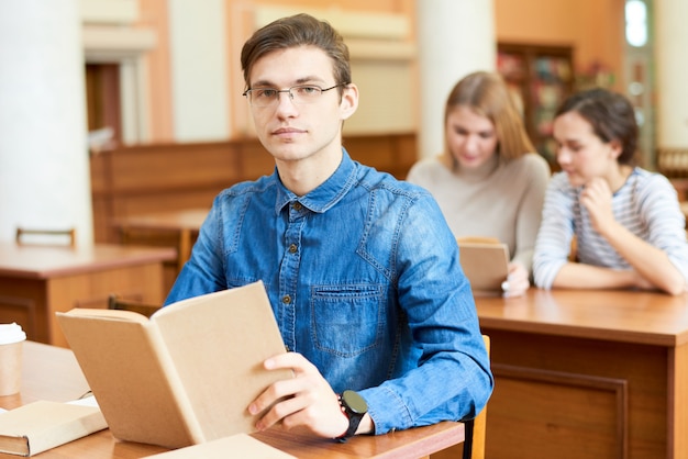 Ambitny student uniwersytetu spędzający czas w bibliotece