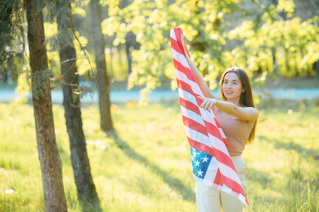 Amerykańska dziewczyna Szczęśliwa młoda kobieta z flagą USA