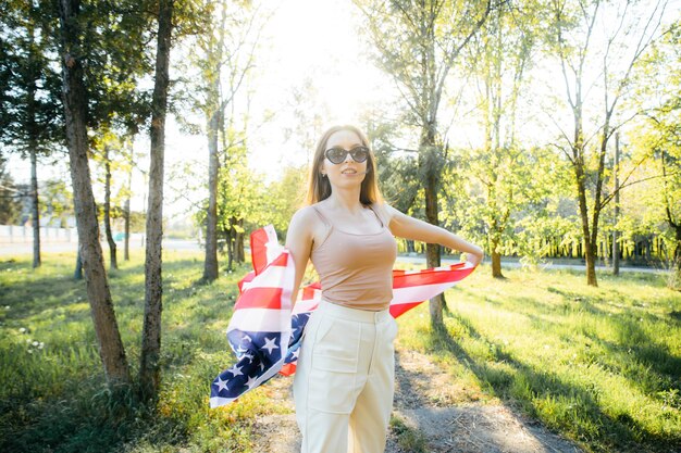 Amerykańska dziewczyna Szczęśliwa młoda kobieta z flagą USA