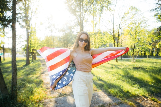 Amerykańska dziewczyna Szczęśliwa młoda kobieta z flagą USA