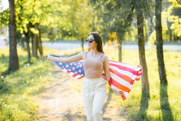 Amerykańska dziewczyna Szczęśliwa młoda kobieta z flagą USA