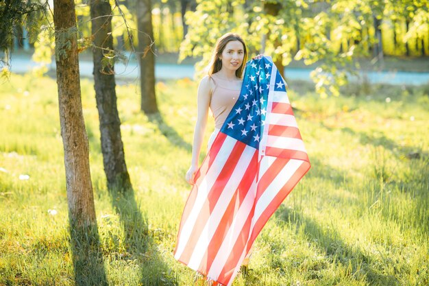 Amerykańska dziewczyna Szczęśliwa młoda kobieta z flagą USA