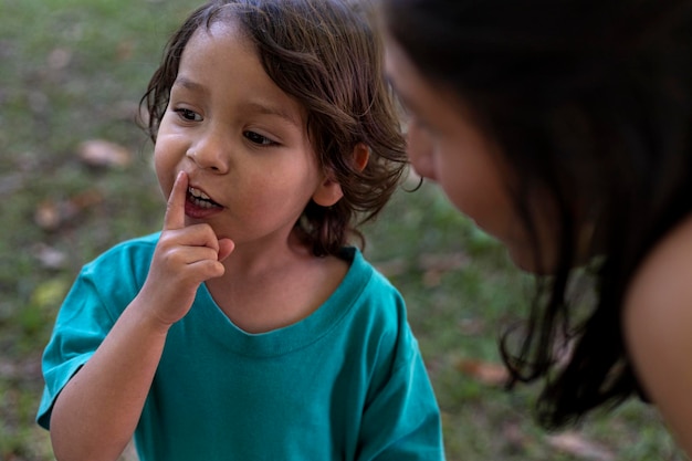 Amerykańska latynoska mama słucha prośby swojego 3-letniego syna w parku Koncepcja dnia rodziny i matki