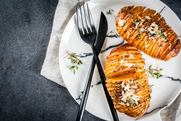 Amerykańska tradycyjna kuchnia domowa. Dieta wegańska. Domowe ziemniaki Hasselback ze świeżymi ziołami i serem