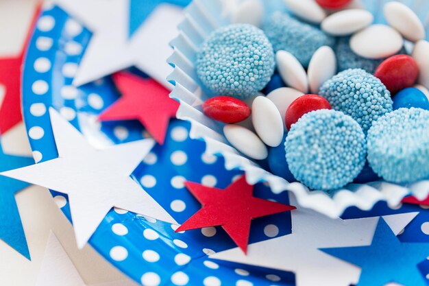 amerykański dzień niepodległości, celebracja, patriotyzm i koncepcja świąt - zbliżenie przeszklonych słodkich cukierków z dekoracją gwiazd na imprezie tematycznej 4 lipca