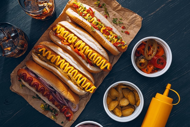 Amerykański hot dog ze składnikami na ciemnym drewnianym tle