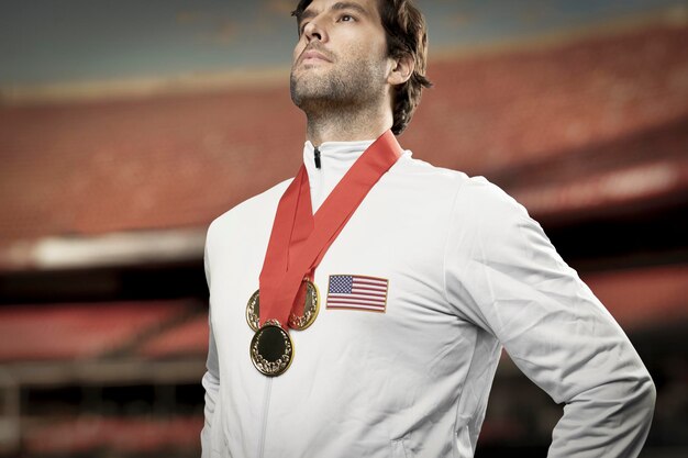 Zdjęcie amerykański sportowiec uśmiecha się po zdobyciu złotego medalu na stadionie świętując swoje zwycięstwo
