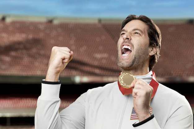 Zdjęcie amerykański sportowiec uśmiecha się po zdobyciu złotego medalu na stadionie świętując swoje zwycięstwo