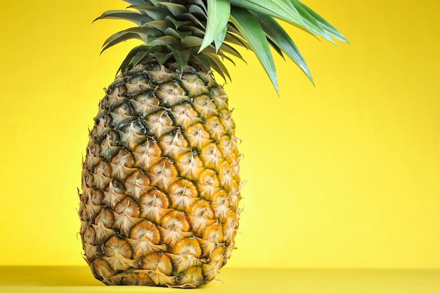 Ananas na jasnym żółtym tle. Świeży ananas na jasnym żółtym tle. Letni owoc.