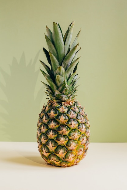 ananas z bliska na żółto-zielonej ścianie