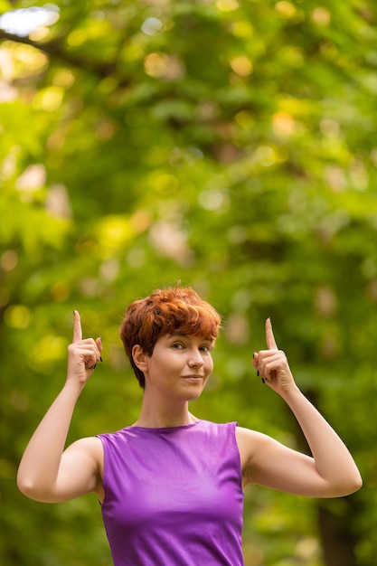 Androgyniczna kobieta wskazująca w parku