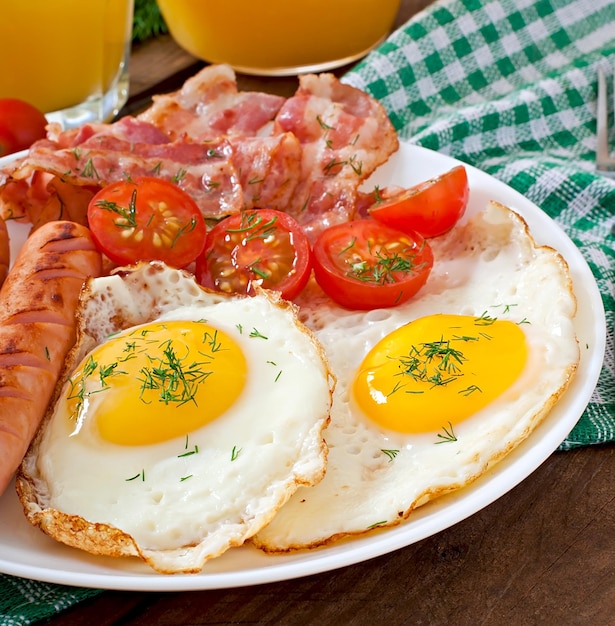 Angielski śniadaniowy toast z jajem, bekonem i warzywami w stylu wiejskim na drewnianym tle