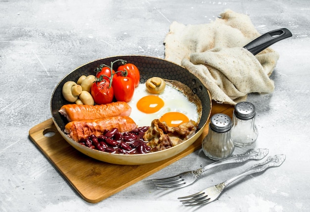 Zdjęcie angielskie śniadanie jajka sadzone z kiełbaskami, bekonem i fasolą