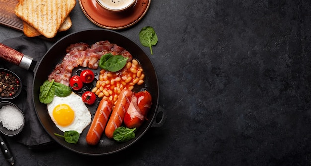 Angielskie śniadanie z jajkiem sadzonym, fasolką, boczkiem i kiełbaskami