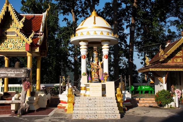 Anioł bóstwa i posąg Buddy świątyni Wat Phra That Doi Kham dla Tajów i zagranicznych podróżników podróżująca i szanująca modlitwa w mieście Mae Hia 10 listopada 2020 r. w Chiang Mai Tajlandia