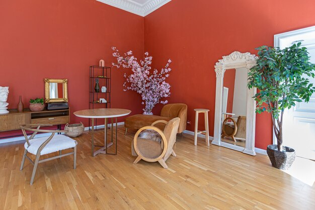 Antyczne zabytkowe wnętrze w XIX-wiecznym salonie w stylu z jasnoczerwonymi ścianami, drewnianą podłogą i bezpośrednim działaniem promieni słonecznych wewnątrz pokoju.